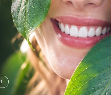 Bright healthy smile framed by green leaves